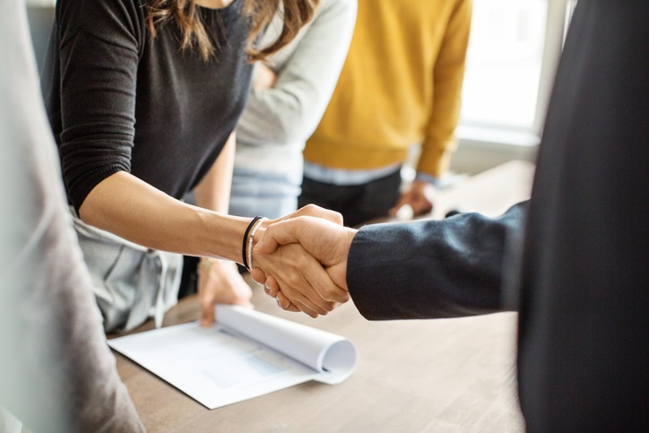 Two people shaking hands at a business deal