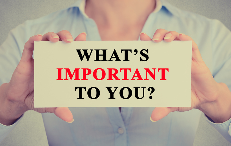 A person holding a sign that says "What's important to you?"