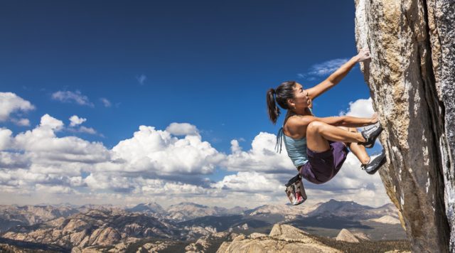 Rock climber clinging to a cliff.