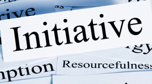 A piece of paper with the word "initiative" surrounded by pieces of paper with synonyms for "initiative" like "resourcefulness" and "gumption"