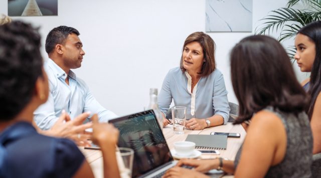 Manager talking to her employees in the office at the formal meeting