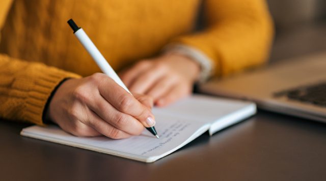 Photo of a woman writing in a journal