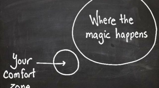A small circle drawn on a chalkboard labeled as "your comfort zone" and a large circle next to it labeled as "where the magic happens"