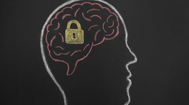 A side profile silhouette drawing of a human head with the brain drawn in pink. There is a gold lock inside the brain with a hole for a key