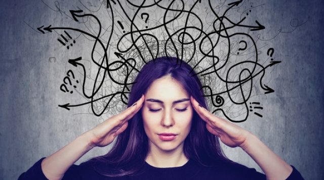 Picture of a woman with her eyes closed and hands at her temples trying to control her thoughts. There are lots of squiggly lines with arrows and different icons to display an array of thoughts