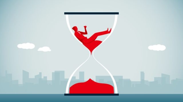 A drawing of an hourglass with red sand in the bottom half and the red shape of a man sitting on red sand in the top half