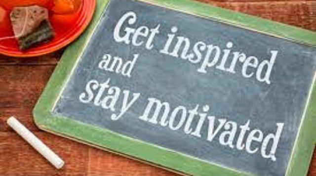 A dry erase board with a green border that says "get inspired and stay motivated" in white chalk