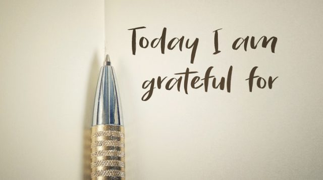 A picture of an open journal with a pen and "today I am grateful for" written on the page
