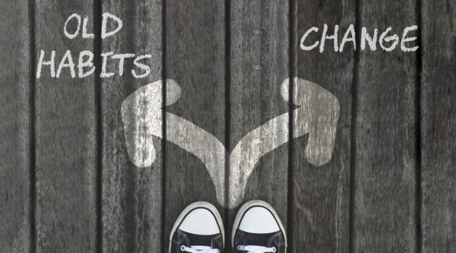 Two arrows drawn on the ground with a pair of shoes facing them. The arrow pointing left says "old habits" and the arrow pointing right says "change"
