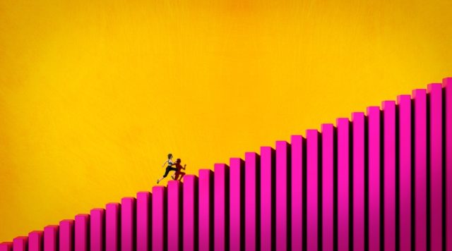 A yellow background with bright pink ascending stairs in the foreground. A person is running up the steep stairs