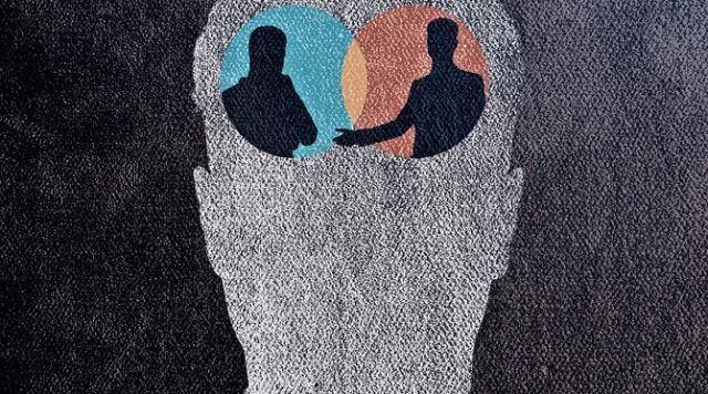 The outline of a human head with two silhouetted figures facing each other within the head, located where the brain would be. Each silhouette is set within a colored circle — one blue (left), the other orange/red (right) — with a small overlapping area in the center (reminiscent of a Venn diagram).