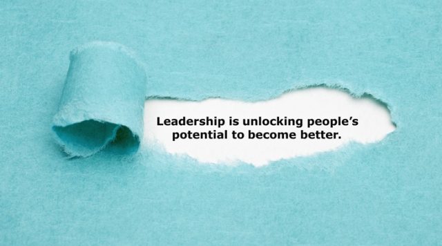 A background of blue paper with a piece in the middle torn away, revealing the words "Leadership is unlocking people's potential to become better."