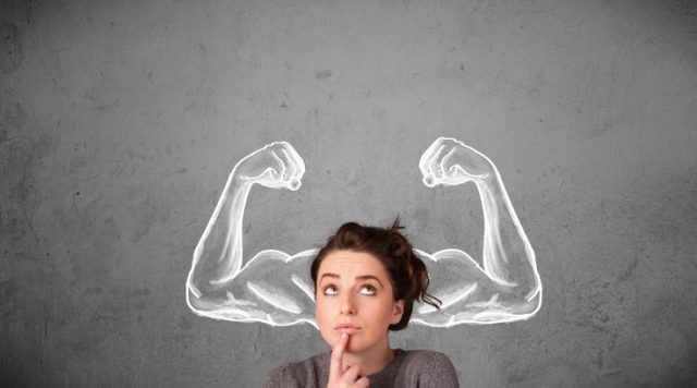 A young woman who looks like she is thinking, with 2 illustrated arms flexing muscles on either side of her head