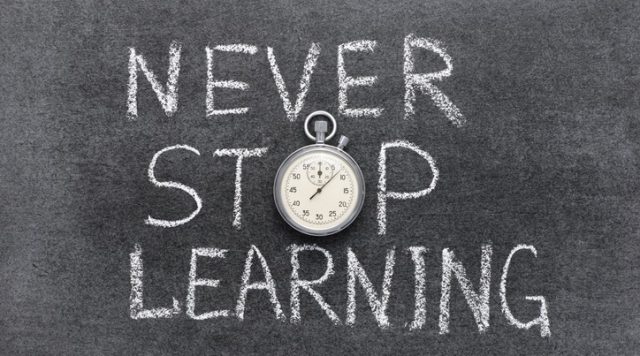 The words "never stop learning" written on a chalkboard. the "o" in "stop" is a stopwatch