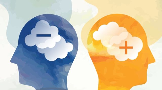Picture of 2 human head silhouettes, one blue with a negative sign and one yellow with a positive sign, to depict negative vs positive thinking