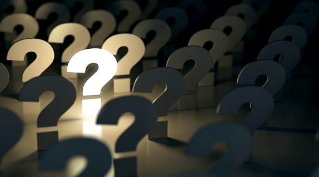 Question marks against a dark background, one is lit up