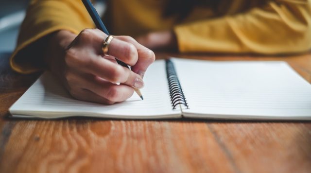 Picture of a person writing in a journal